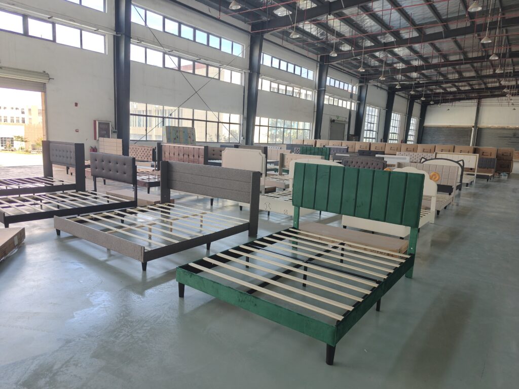 A spacious warehouse displaying various modern bed frames in different designs and colors.