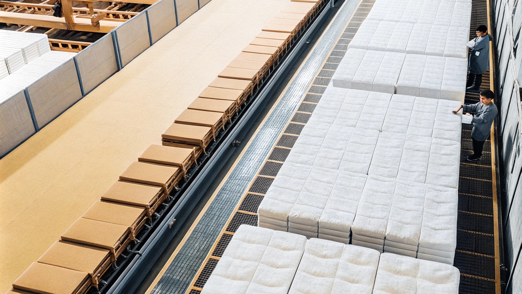 Workers managing large-scale factory production with boxes and neatly stacked items.