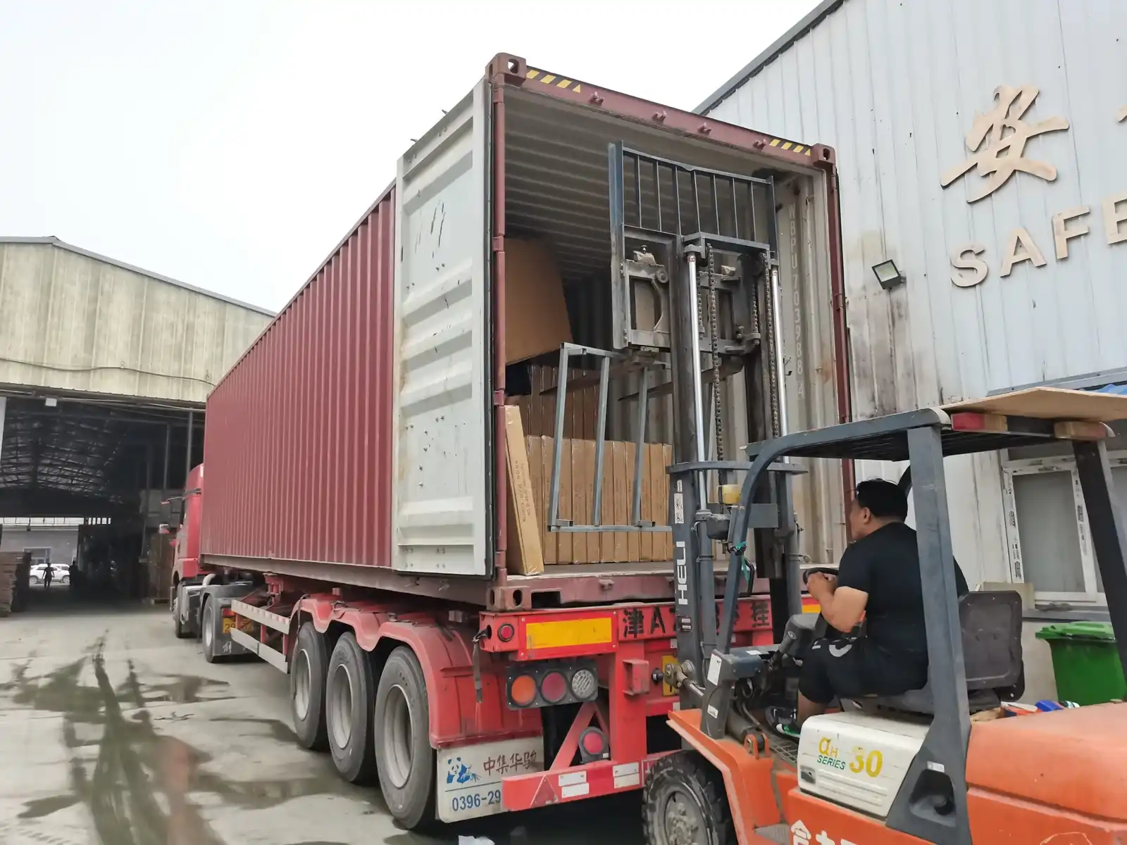 Workers loading a container with bed frames