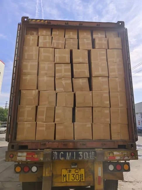 A shipping container being loaded with mattresses for export
