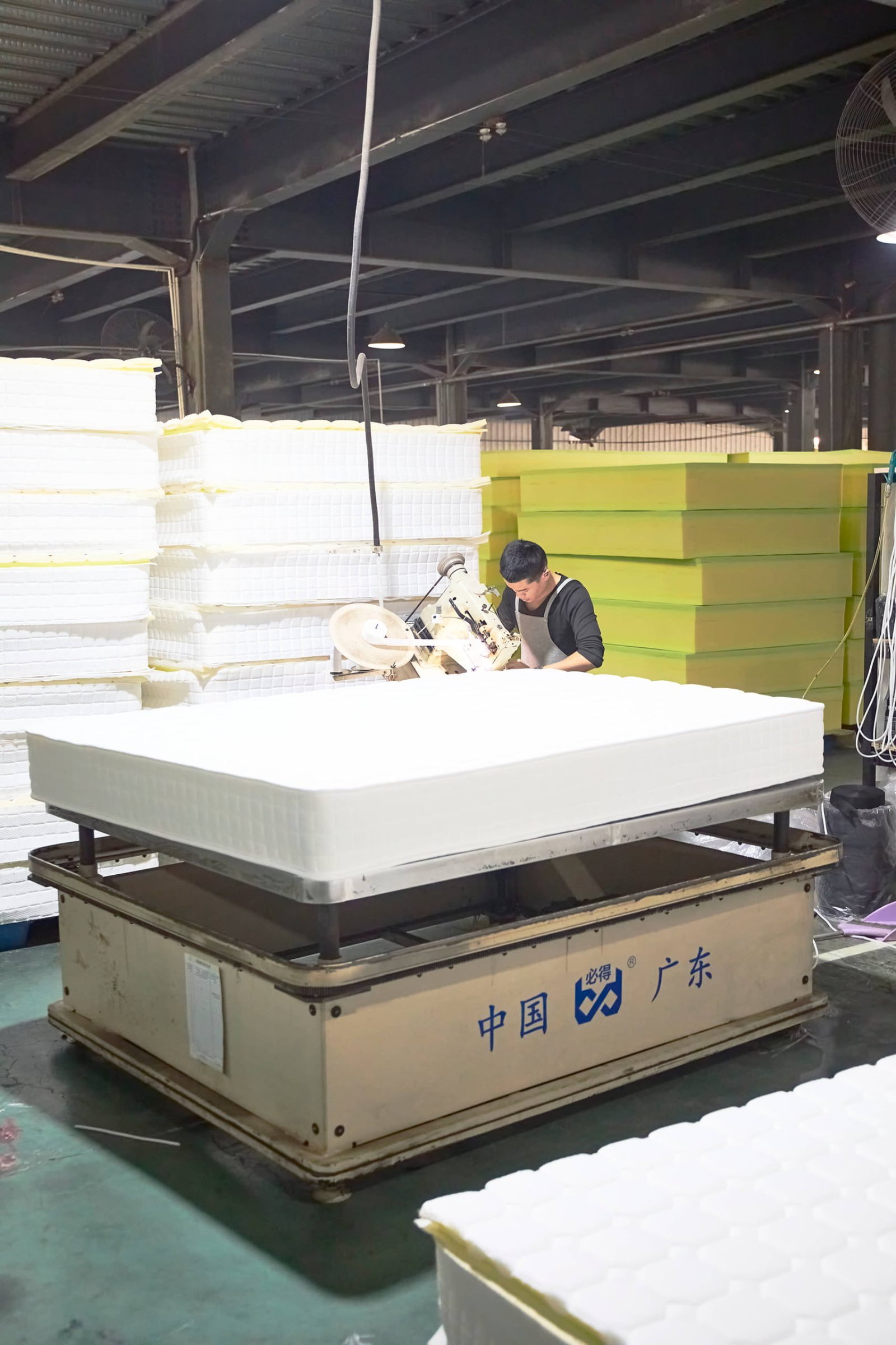 Mattress Quality Control Criteria A quality inspector checking the stitching on a mattress