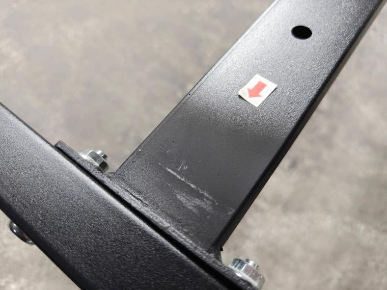 Metal bed frame component with a paint finish defect marked during inspection