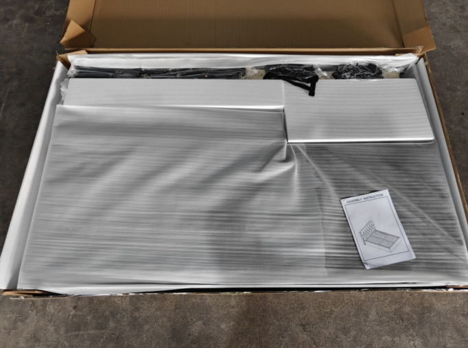 Opened carton showing protective wrapping around packaged bed components