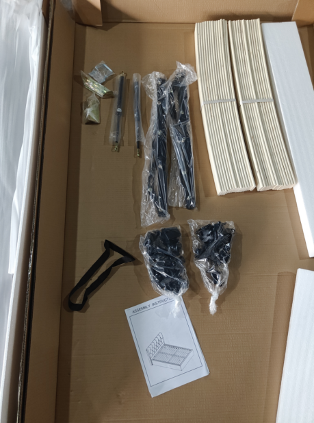 Bed frame components and hardware arranged inside a carton