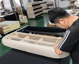 Upholstery work on a bed frame during production
